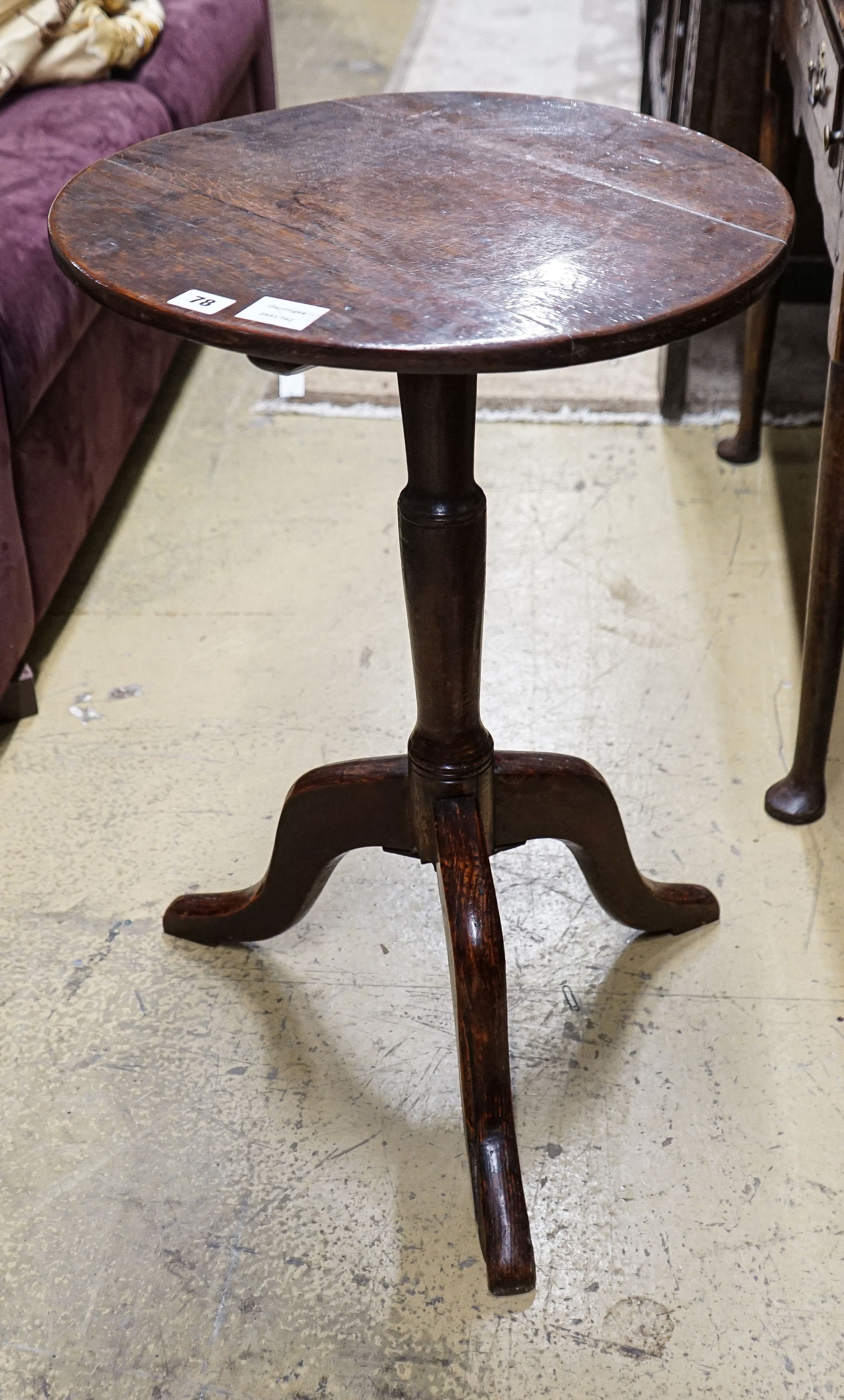 A George III oak tripod table, with circular top and slender baluster stem, diameter 46cm height 72cm